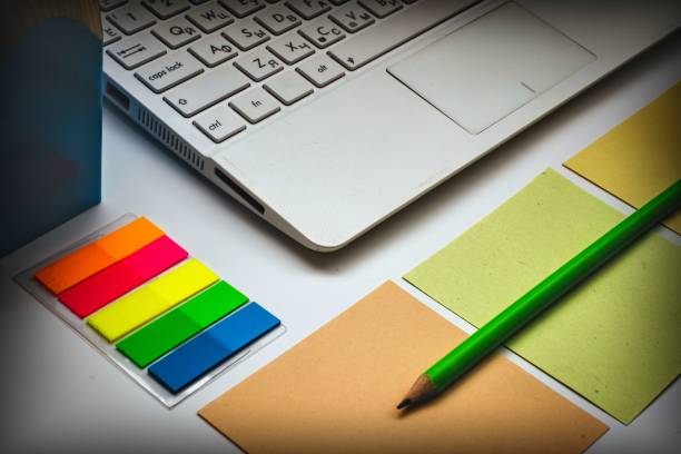 istock notebook, pen, computer keyboard and colored pieces of paper on a white background 1177502993
