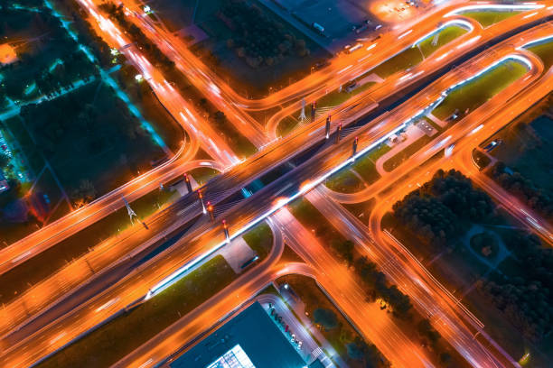 istock Large bridge with road junction illuminated by lanterns at night, markings on asphalt are visible, night aerial top view. 1177505563