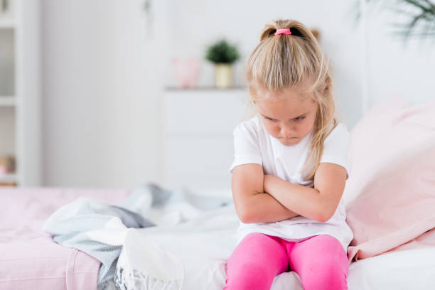 istock Offended or bored child crossing arms on chest while sitting on couch 1177506625
