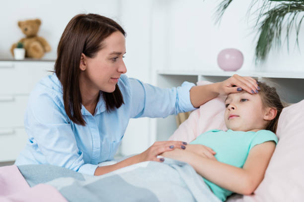 istock Young brunette woman looking at her sick daughter while touching forehead 1177507003