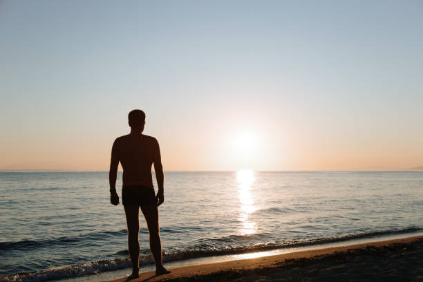 istock Young man looking at sunset by the sea 1177508731