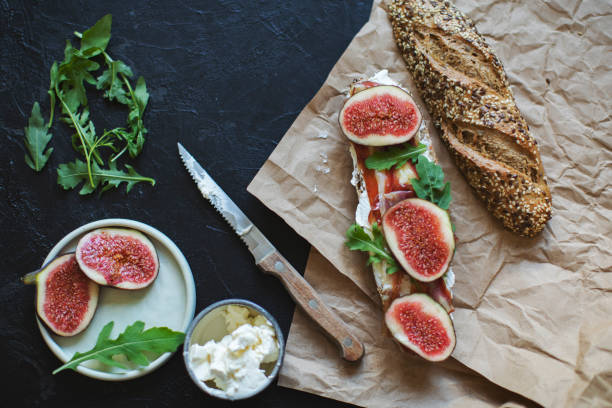 Healthy sandwich with bread, cream cheese, prosciutto, figs