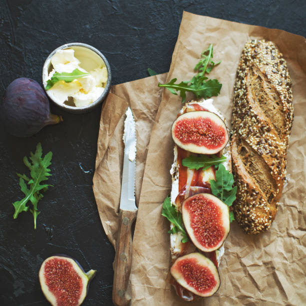 Healthy sandwich with bread, cream cheese, prosciutto, figs