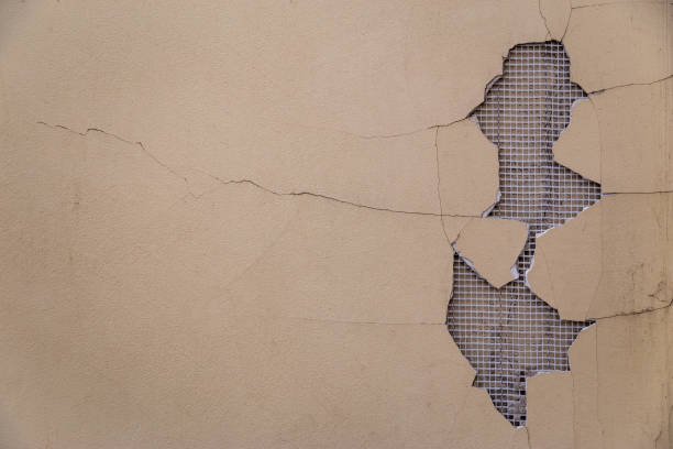 istock Big stucco fail on the wall with pavement crack and lattice holding bricks seen from the back. 1177513019