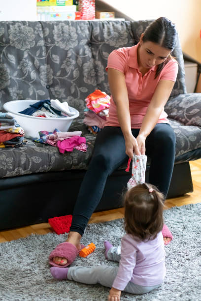 istock Mother and little daughter doing laundry at home 1177514151