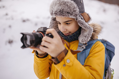 Boy photographing using dslr camera during winter vacation