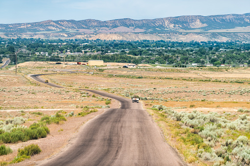 Jensen or Vernal Utah road highway with view of city near Dinosaur National Monument desert landscape