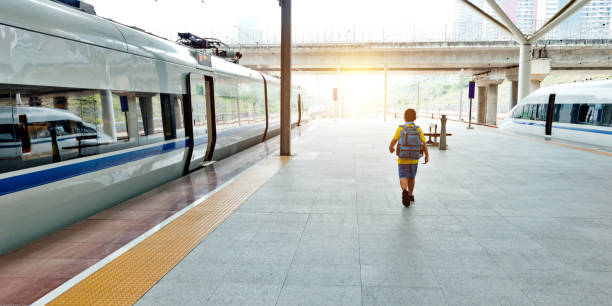 istock Boy walking on railroad station platform 1177541058