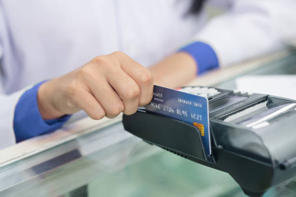 Hand of  pharmacist, chemist making purchases, Paying with a credit card Hand of  pharmacist, chemist making purchases, Paying with a credit card and using a terminal on many medicines shelf in pharmacy background. smart card stock pictures, royalty-free photos & images