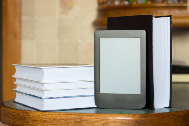 istock Modern e-book on the background of a stack of thick paper books. Close-up with selective focus. Training and technology concept 1177546729