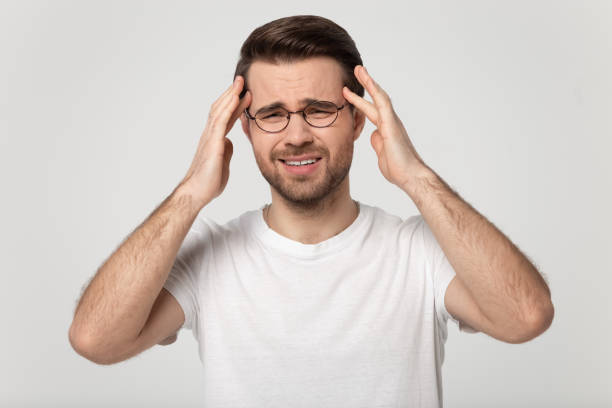 istock Tired millennial man massaging temples, suffering from sudden headache. 1177546756