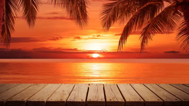 Photo of Empty wooden platform beside sea with beautiful sunset