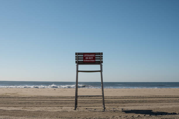 An empty lifeguard chair by itself at the beach.