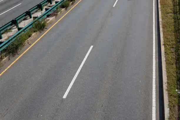 Overhead view of asphalt roadway, median with guardrails, horizontal aspect