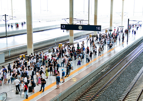 Multitud de pasajeros esperando en la plataforma de la estación photo