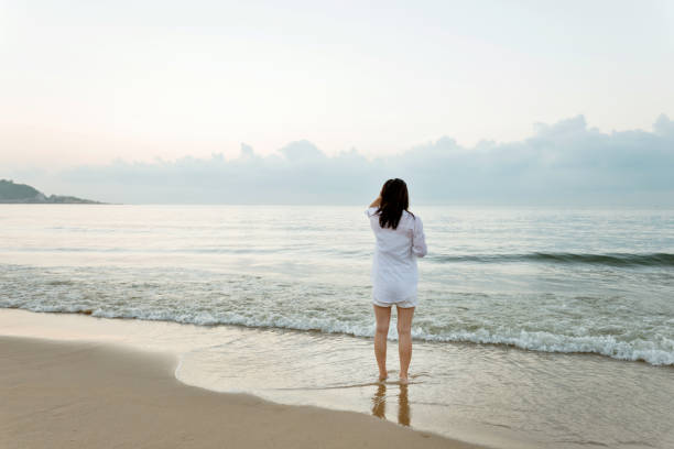 istock Young woman standing on beach 1177568013