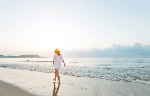 istock Woman walking on the beach 1177568014