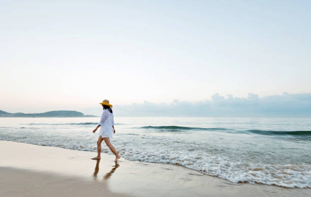 istock Woman walking on the beach 1177568037