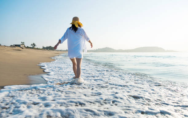 istock Woman walking on the beach 1177568670