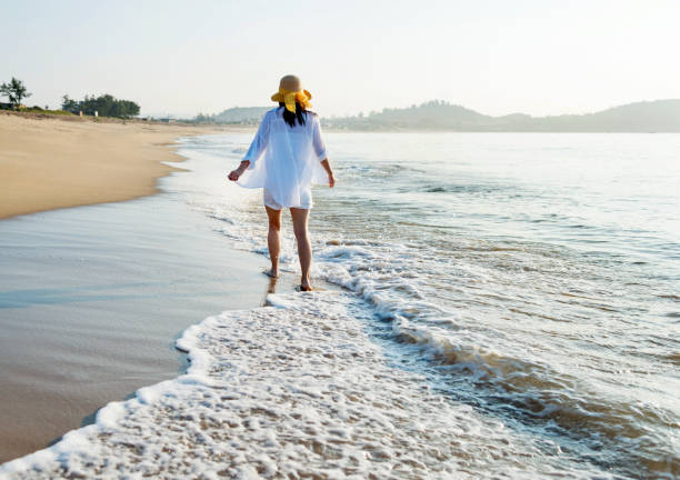 istock Woman walking on the beach 1177568715