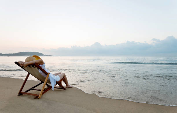 istock Woman relaxing on deck chair at the beach 1177568922