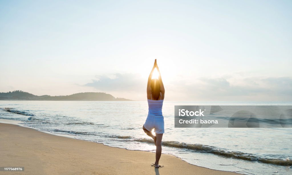 Foto de Mulher Que Faz A Ioga Na Praia e mais fotos de stock de Yoga - Yoga,  Praia, Mulheres - iStock