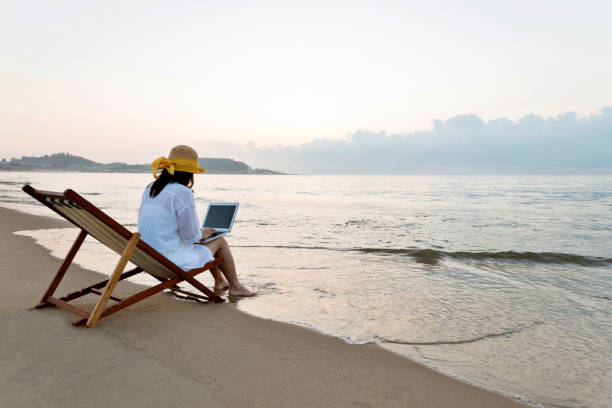 mujer usando laptop en la playa - one person beautiful barefoot beach fotografías e imágenes de stock