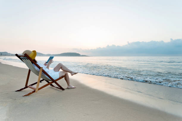 istock Woman using digital tablet at the beach 1177569098