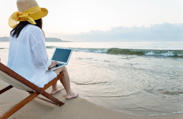 istock Woman using laptop at the beach 1177569777