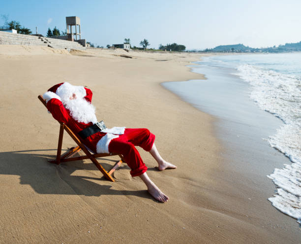 istock Santa Claus resting on deck chair at beach 1177570056