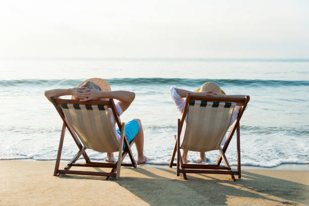 istock Couple sitting on deck chair at beach 1177570783