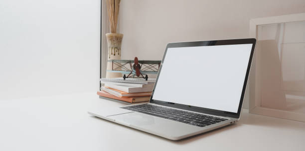 istock Open blank screen laptop with coffee cup and office supplies in minimal workplace 1177574769