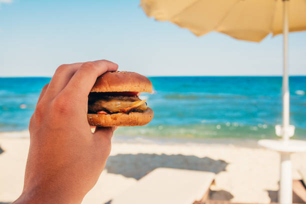 istock eating burger at the beach 1177581293