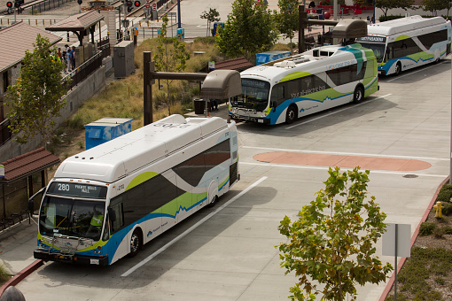 Azusa, California /USA - September 15, 2019: Foothill Transit Buses await passengers from the incoming Gold Line metro train.