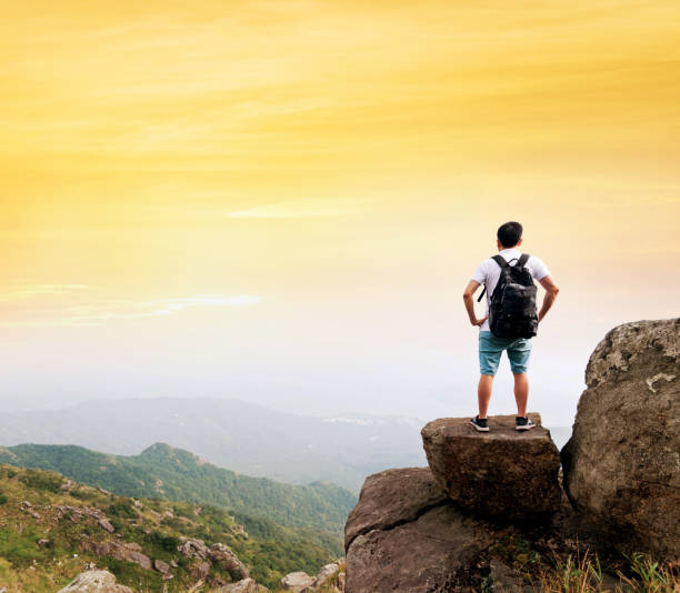 istock Man backpacker on the top of mountain at sunset 1177585849