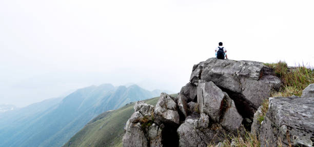 Man backpacker sitting on the top of mountain.