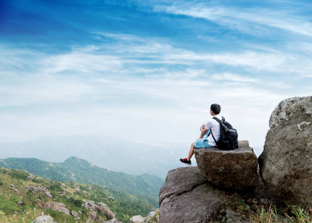 istock Man backpacker sitting on the top of mountain 1177586660