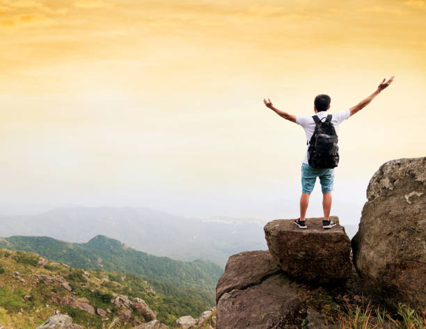 istock Man backpacker on the top of mountain at sunset 1177587790
