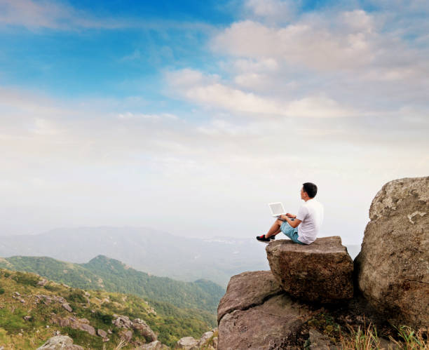 istock Man using laptop on top of mountain 1177589089