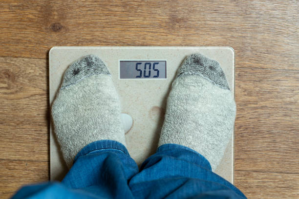 istock A man is weighed on the scales, top view. COC inscription 1177590410