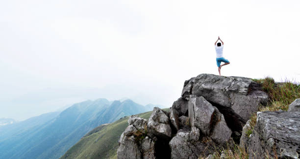 istock Man doing yoga on top of mountain 1177590542
