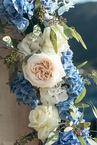 Close-up decoration of fresh blue hydrangeas and white peony roses at a wedding or other event. Decoration with flowers.