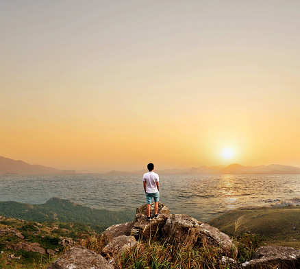 Man on top of the cliff near the sea.