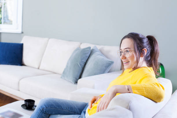istock Happy woman sitting on couch weekend at home 1177592856