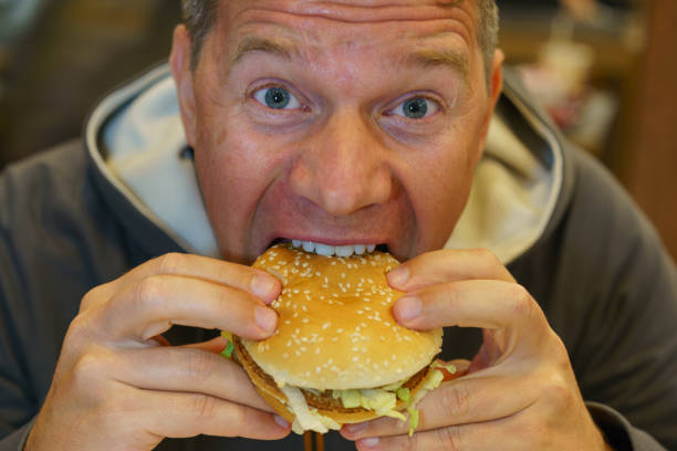 istock Man eating fast food in cafe and unsatisfied with it 1177601687