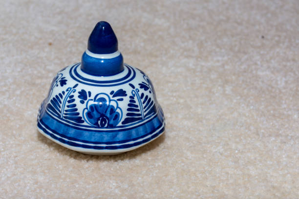 adorno holandés delft blau (azul) hecho a mano con diseños de flores azules y porcelana de porcelana sobre un fondo beige aislado. países bajos. - dutch culture delft souvenir blue fotografías e imágenes de stock