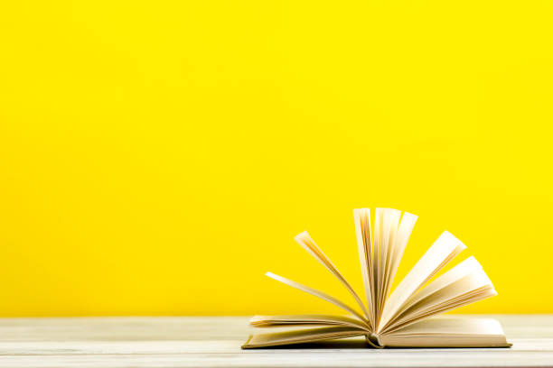 istock Open book, hardback books on wooden table. Back to school. Copy space. 1177608399
