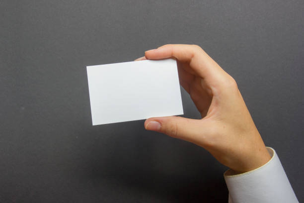 Hand holding white business card on white background