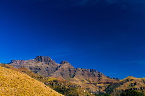 Cathkin peak and champagne castle seen from the cathkin Valley Cathkin peak and champagne castle seen from the cathkin Valley on a bright winter morning in south Africa drakensberg mountain range stock pictures, royalty-free photos & images