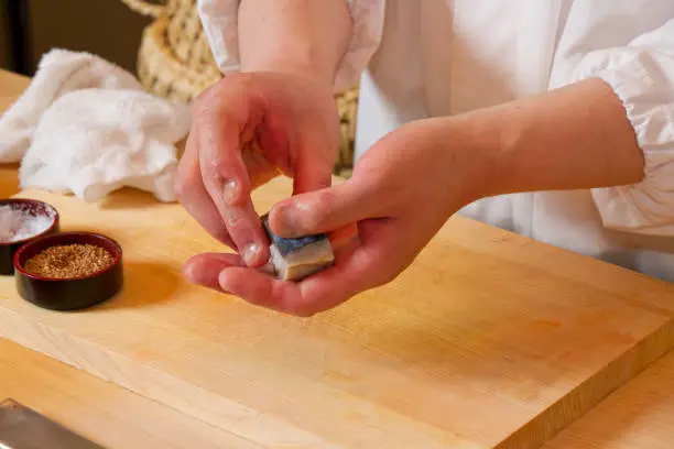 Sushi craftsman holding sushi